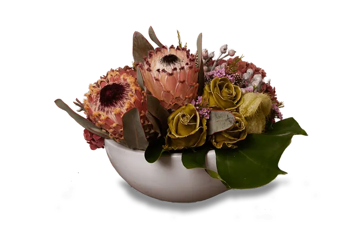 Witte schaal met protea, groengele waxrozen en groot blad